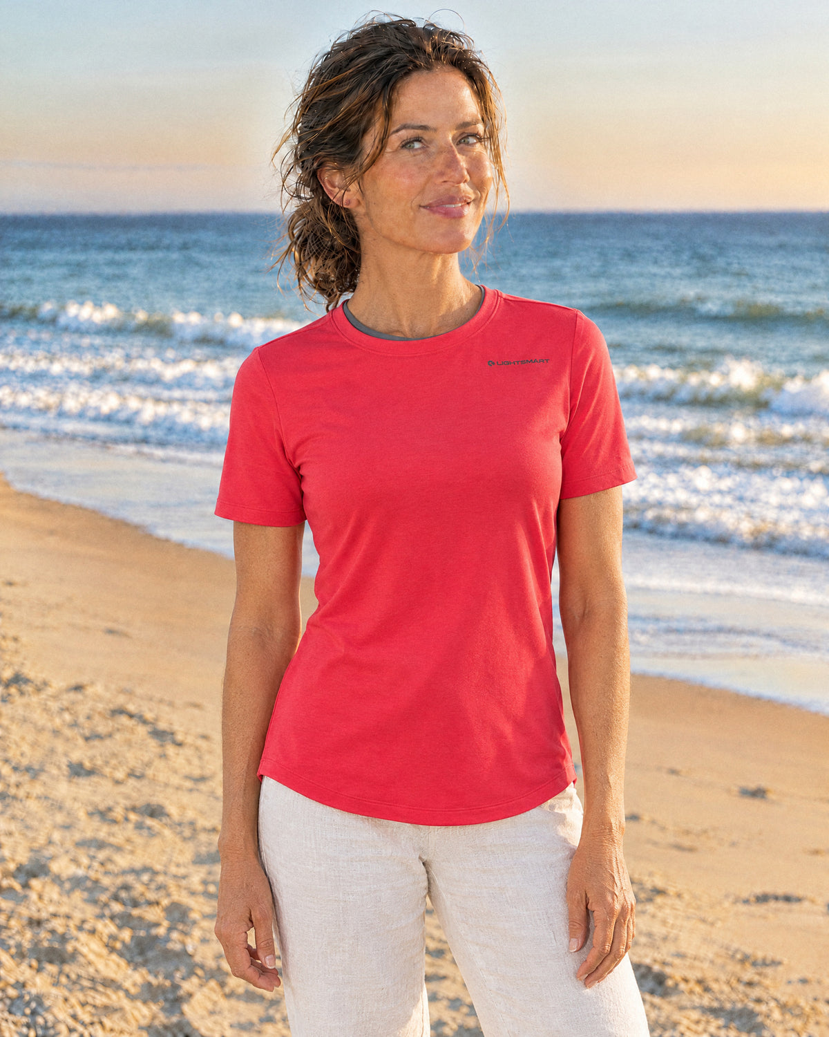 A woman on the beach in the Halo SW1 women's short sleeve in Shockwave